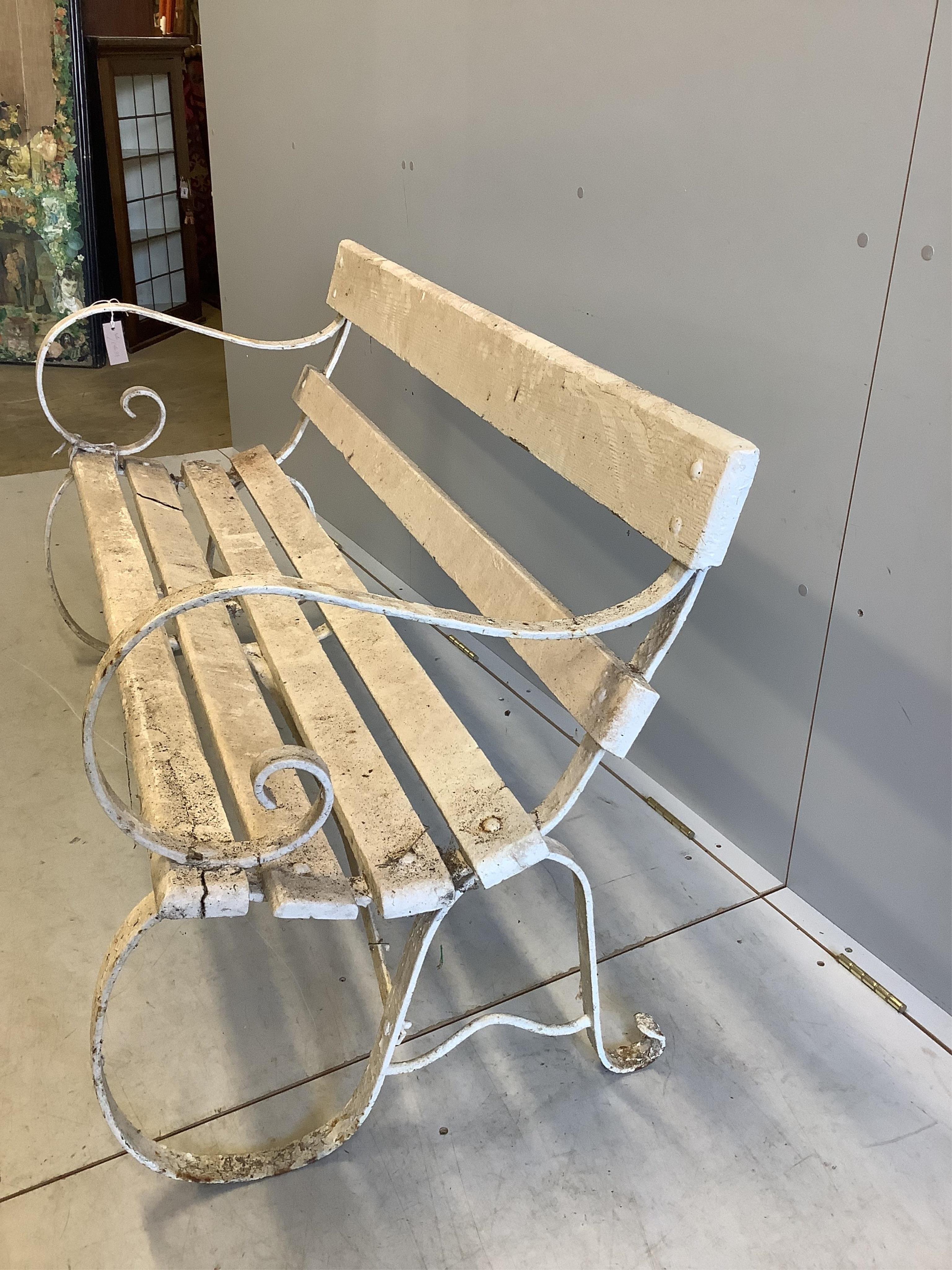 A white painted slatted wood garden bench with wrought iron ends, width 137cm, depth 63cm, height 78cm. Condition - poor to fair